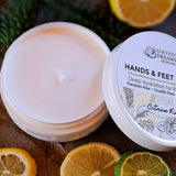 Open jar of Citrus Kiss hands and feet lotion showing smooth cream texture.