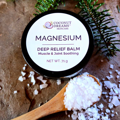 Coconut Dreams Skincare magnesium deep relief balm tin with sea salt crystals and evergreen sprigs.