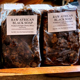 Close-up of a rustic block of African black soap showing the uneven, natural surface. Crafted from Ghana, Africa.